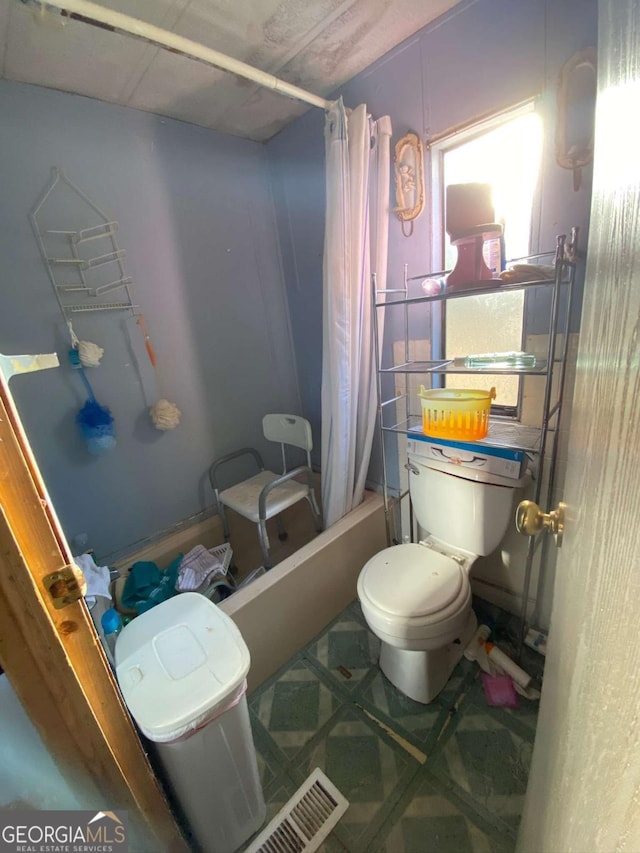 bathroom featuring shower / bath combination with curtain and toilet