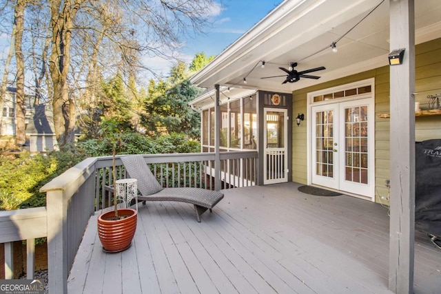 wooden deck featuring french doors, ceiling fan, and a sunroom