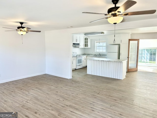 kitchen with white cabinetry, white appliances, a center island, and light hardwood / wood-style floors