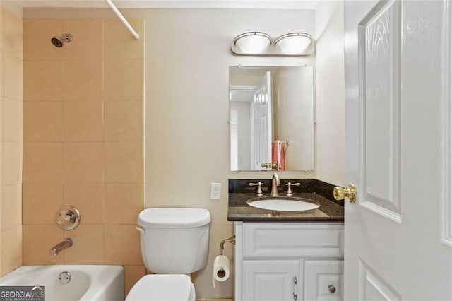 full bathroom featuring tiled shower / bath, vanity, and toilet