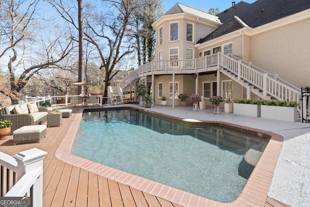 view of swimming pool with a fenced in pool, stairway, a deck, a patio area, and an outdoor living space