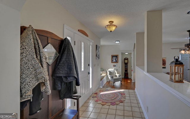 tiled entryway featuring a textured ceiling