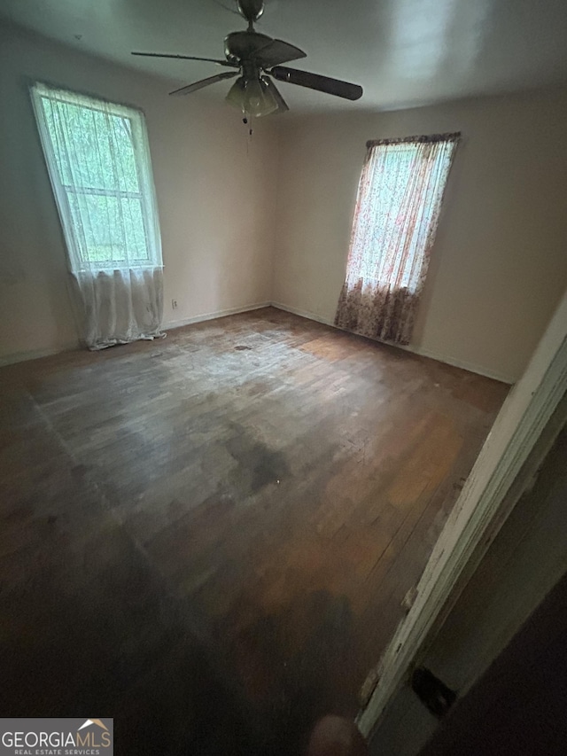 unfurnished room featuring dark wood-type flooring and ceiling fan