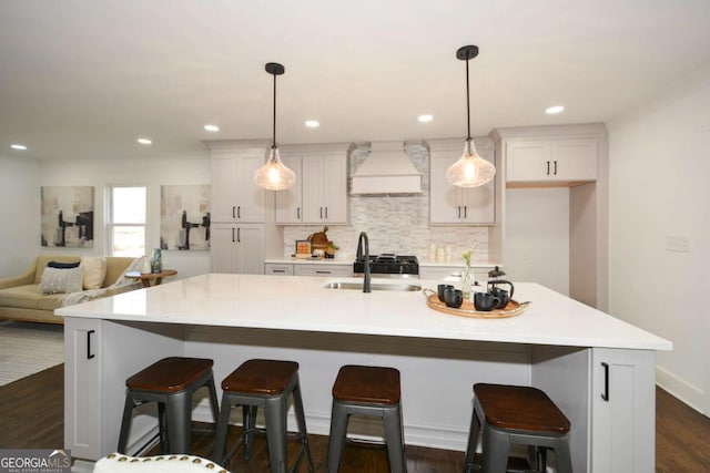 kitchen with pendant lighting, a kitchen breakfast bar, custom range hood, and a spacious island