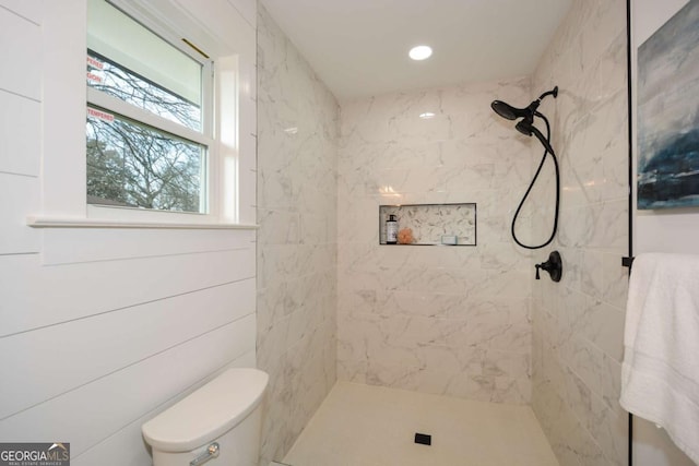 bathroom featuring toilet and a tile shower