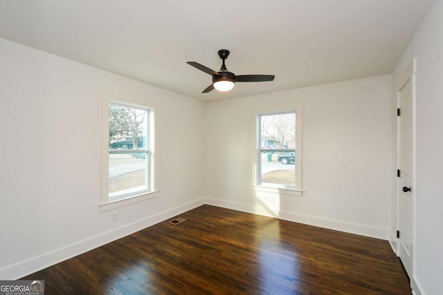 empty room with dark hardwood / wood-style flooring and ceiling fan