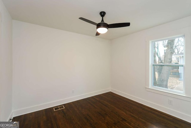 spare room with dark wood-type flooring and ceiling fan