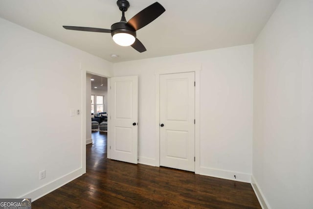 unfurnished bedroom with dark wood-type flooring and ceiling fan