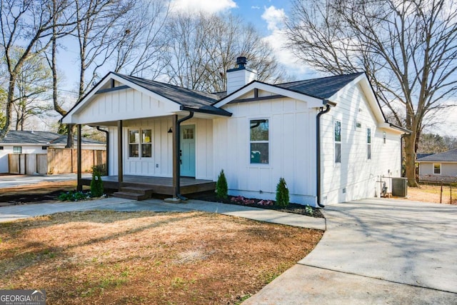 modern farmhouse style home with central AC unit and covered porch