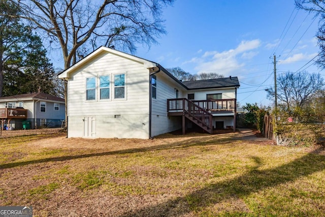 rear view of property featuring a yard and a deck