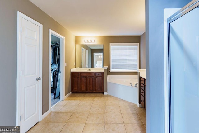 bathroom with tile patterned floors, shower with separate bathtub, and vanity