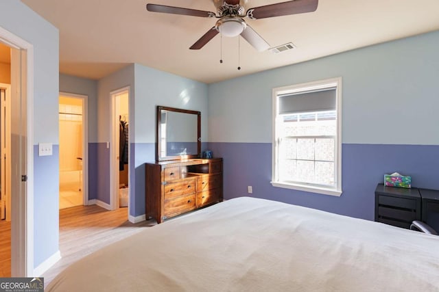 bedroom with ceiling fan, connected bathroom, and light hardwood / wood-style floors