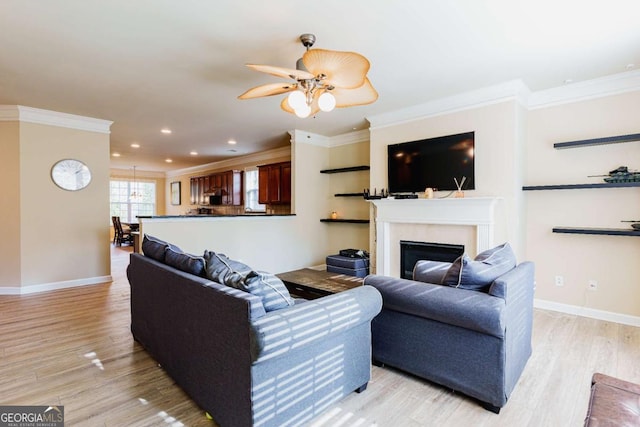 living room with crown molding, ceiling fan, and light hardwood / wood-style flooring