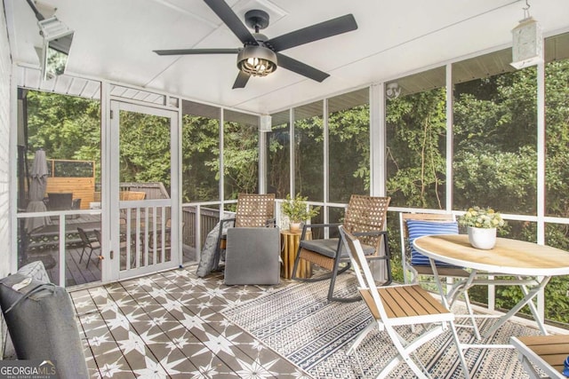 unfurnished sunroom featuring ceiling fan