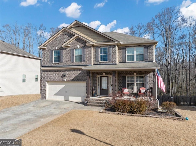 craftsman-style house featuring concrete driveway, an attached garage, fence, a porch, and brick siding