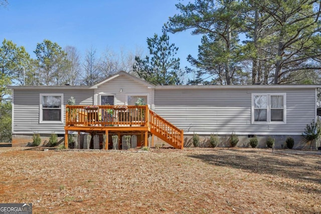 back of property with a yard and a deck