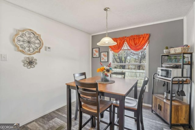 dining area featuring dark wood-type flooring and a textured ceiling