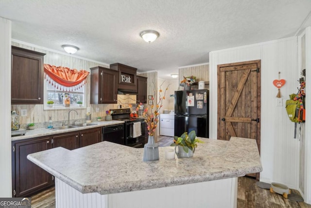 kitchen featuring a center island, sink, dark brown cabinets, and black appliances