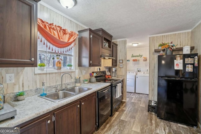 kitchen with dark brown cabinetry, sink, crown molding, washing machine and dryer, and black appliances