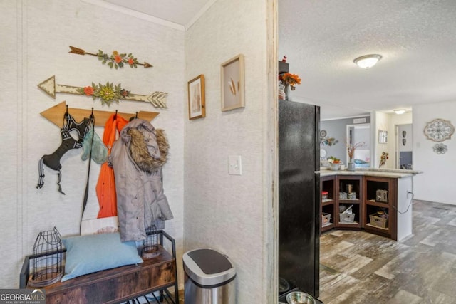 mudroom with hardwood / wood-style flooring, ornamental molding, and a textured ceiling