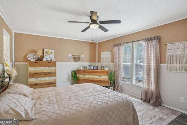 bedroom with crown molding, ceiling fan, and a textured ceiling