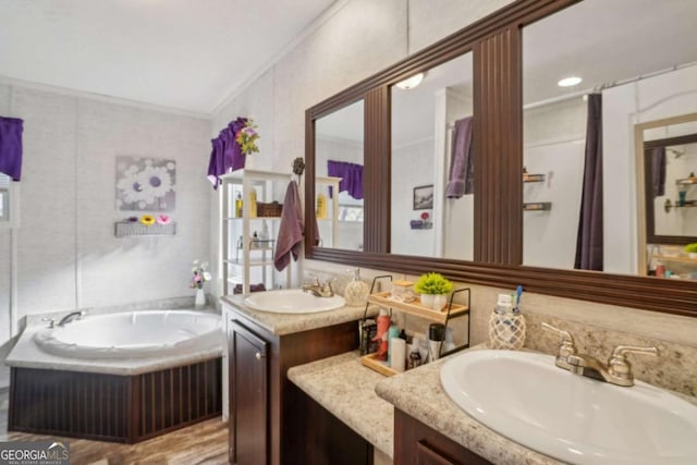 bathroom with ornamental molding, vanity, and a tub to relax in