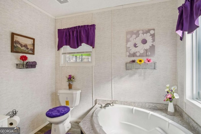 bathroom with a washtub, crown molding, and toilet