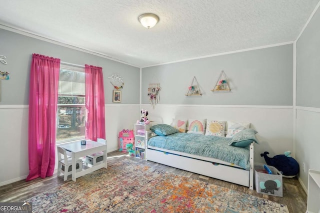 bedroom featuring hardwood / wood-style flooring, ornamental molding, and a textured ceiling