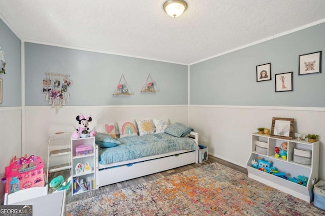 bedroom with hardwood / wood-style flooring, ornamental molding, and a textured ceiling