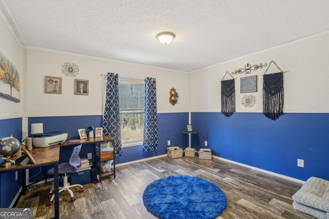 home office featuring wood-type flooring, ornamental molding, and a textured ceiling