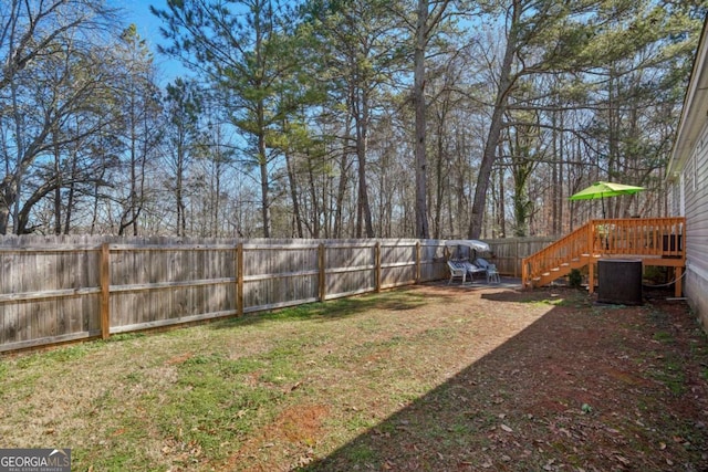 view of yard featuring a wooden deck and central AC unit