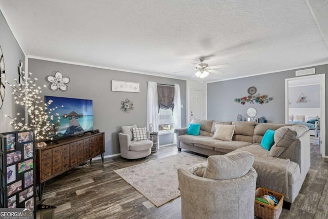 living room with ornamental molding, dark wood-type flooring, ceiling fan, and a textured ceiling