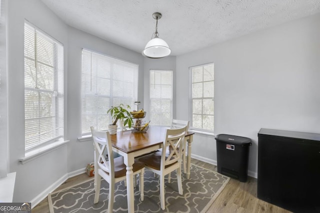 dining room with hardwood / wood-style floors and a textured ceiling