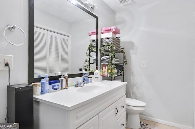 bathroom with tile patterned flooring, vanity, and toilet