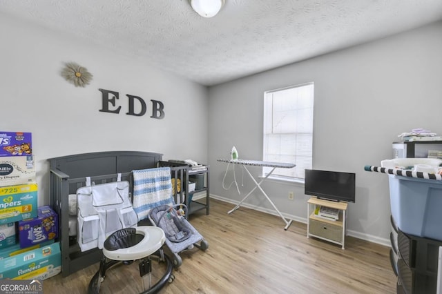 bedroom featuring wood-type flooring and a textured ceiling