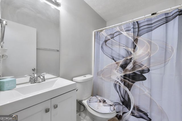 bathroom featuring vanity, toilet, and a textured ceiling