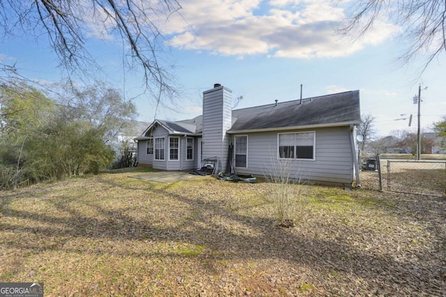 back of house with a patio area and a lawn