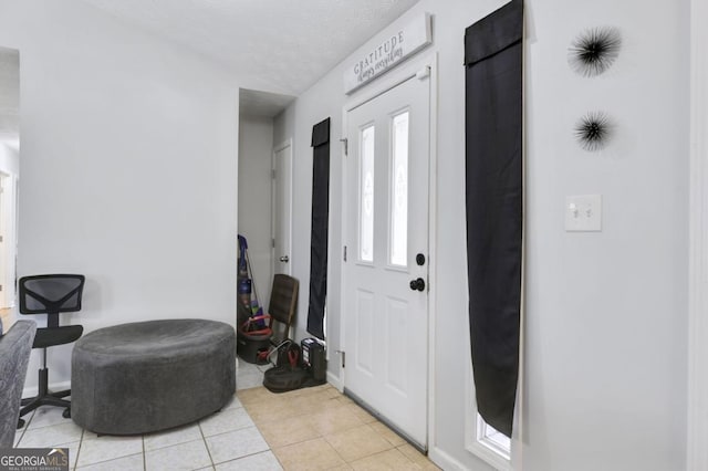 tiled entrance foyer with a textured ceiling