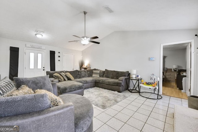 living room with light tile patterned flooring, lofted ceiling, and ceiling fan