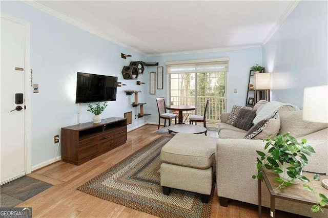 living area featuring ornamental molding, baseboards, and wood finished floors