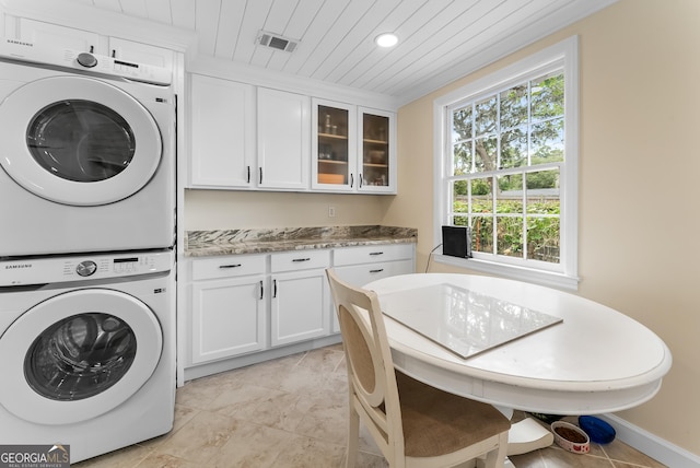 washroom featuring wood ceiling, cabinets, and stacked washer / dryer