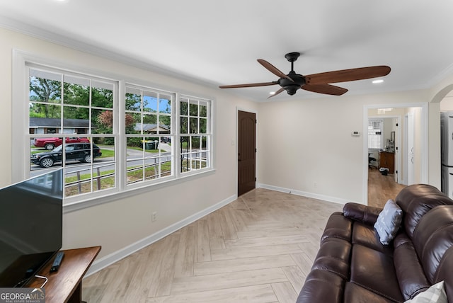 living room featuring light parquet flooring, crown molding, and ceiling fan