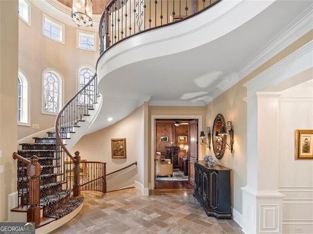 foyer featuring ornamental molding and a high ceiling