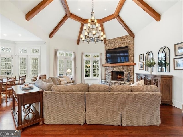 living room with a stone fireplace, high vaulted ceiling, a notable chandelier, and dark hardwood / wood-style flooring