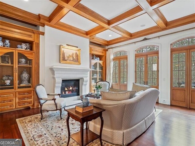 interior space featuring built in features, beam ceiling, dark hardwood / wood-style floors, coffered ceiling, and french doors