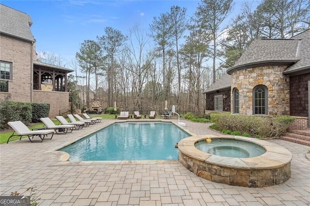 view of swimming pool with a patio area and an in ground hot tub