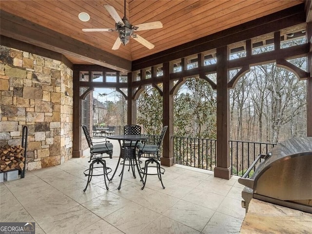 sunroom with plenty of natural light, wooden ceiling, and ceiling fan