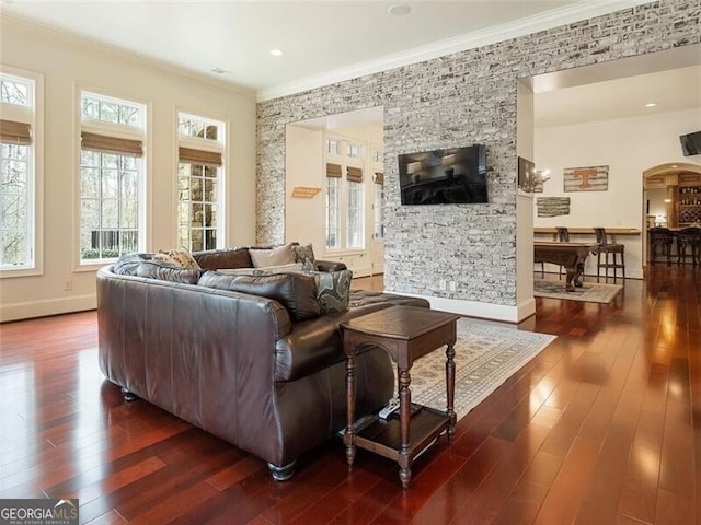 living room featuring dark wood-type flooring, ornamental molding, and plenty of natural light