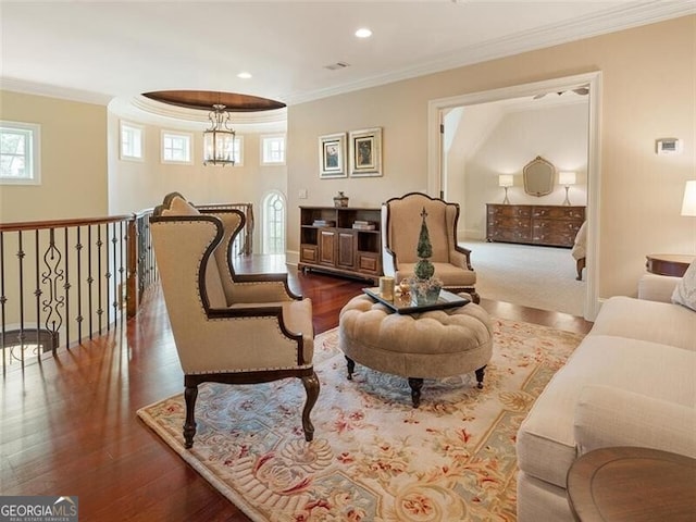 sitting room featuring hardwood / wood-style flooring, ornamental molding, and an inviting chandelier