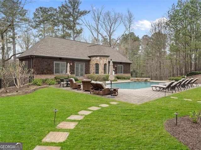 rear view of house with a lawn and a patio